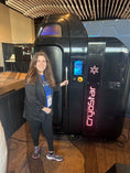 Load image into Gallery viewer, Person standing next to a Cryostar cryosauna at an event.