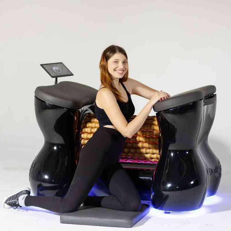 Woman sitting on a futuristic black chair with glowing blue accents against a white background