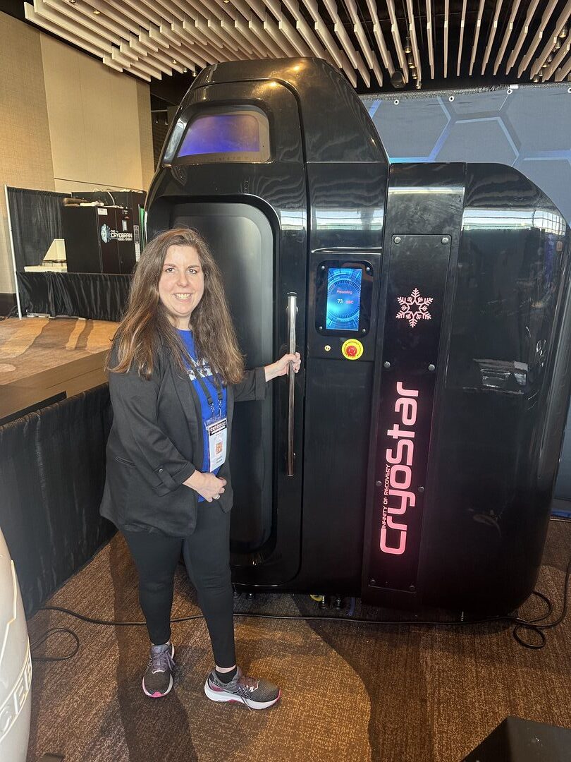 Person standing next to a Cryostar cryosauna at an event.