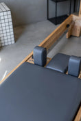 Load image into Gallery viewer, Pilates reformer machine in a studio setting with a neutral background
