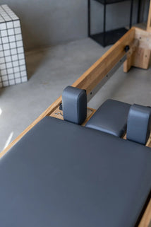 Pilates reformer machine in a studio setting with a neutral background