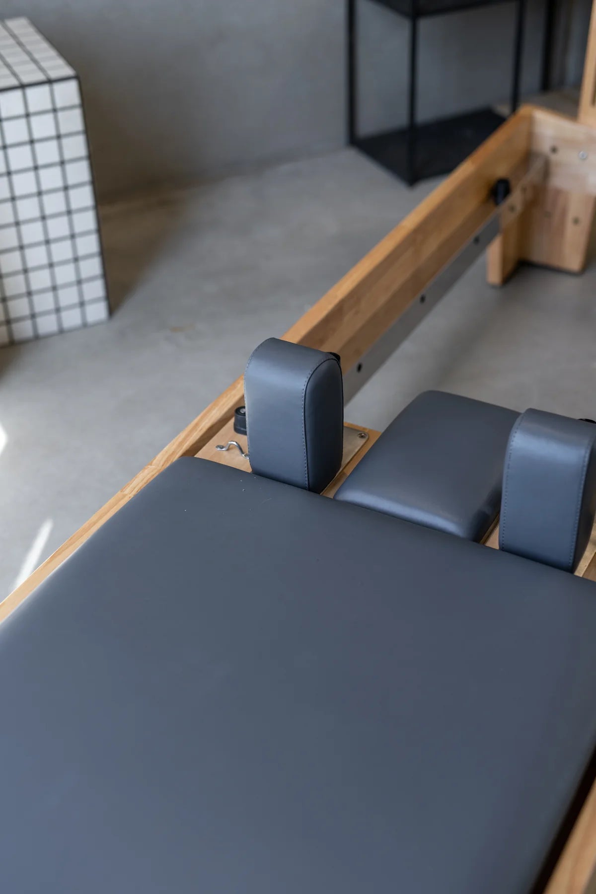 Pilates reformer machine in a studio setting with a neutral background